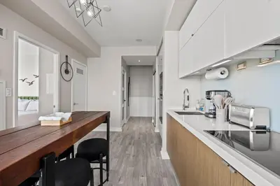 a kitchen with white cabinets and a wooden counter top at High Floor 1 Bedroom Condo Iceboat Terrace Downtown Toronto in Toronto