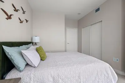 a bedroom with a bed with birds on the wall at High Floor 1 Bedroom Condo Iceboat Terrace Downtown Toronto in Toronto