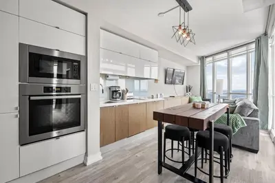 a kitchen and living room with a table and a couch at High Floor 1 Bedroom Condo Iceboat Terrace Downtown Toronto in Toronto