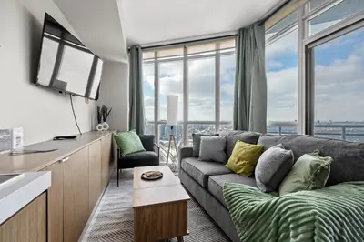a living room with a couch and a large window at High Floor 1 Bedroom Condo Iceboat Terrace Downtown Toronto in Toronto