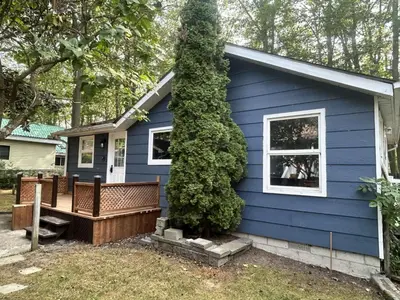 a blue house with a bench in front of it at Lazy Daze (House 2) in Wasaga Beach