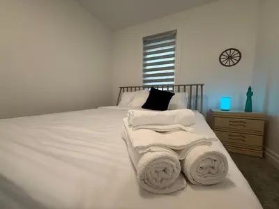 a bedroom with a white bed with towels on it at Upscale Niagara Falls Getaway - BRAND NEW in Niagara Falls