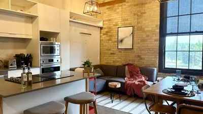 a kitchen and living room with a couch and a table at The Artist's Loft in Stratford