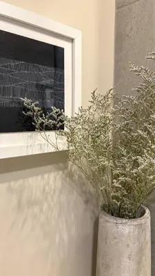 a vase with flowers in it next to a window at The Artist's Loft in Stratford