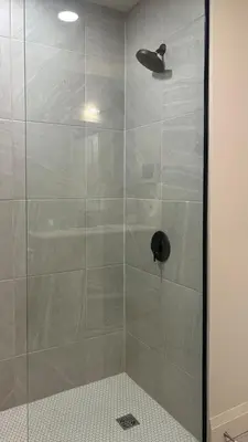 a shower stall with a glass door in a bathroom at The Artist's Loft in Stratford
