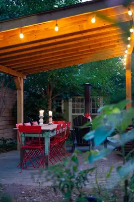 a patio with a table and chairs under a wooden pergola at Sun-Filled Century Home in Hamilton