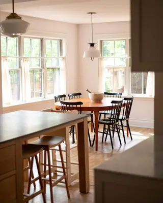 a kitchen with a table and chairs and windows at Sun-Filled Century Home in Hamilton