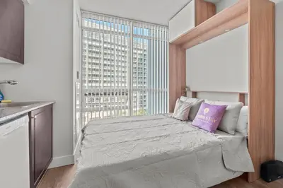 a bedroom with a bed with a large window at Charming Studio in Downtown Toronto in Toronto