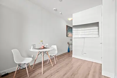 a white dining room with a table and chairs at Charming Studio in Downtown Toronto in Toronto