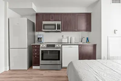a small kitchen with a refrigerator and a microwave at Charming Studio in Downtown Toronto in Toronto