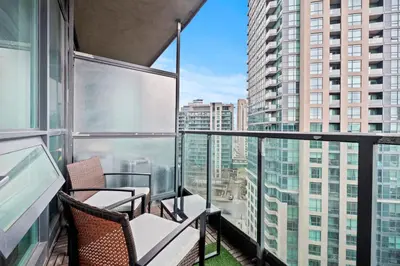 a balcony with chairs and a view of a city at Superior 1Bedroom&DEN Condo with Balcony in Toronto