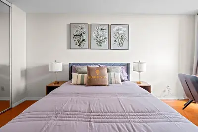 a bedroom with a large bed with three paintings on the wall at Superior 1Bedroom&DEN Condo with Balcony in Toronto