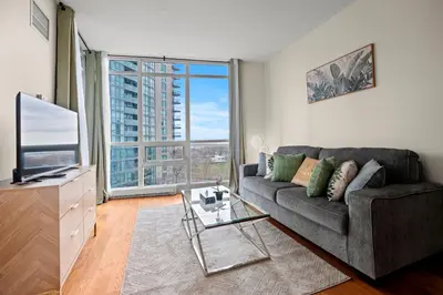 a living room with a couch and a large window at Superior 1Bedroom&DEN Condo with Balcony in Toronto