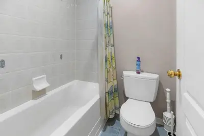 a white bathroom with a toilet and a shower at Cozy Family Home Netflix Backyard and Quiet Area in Mississauga