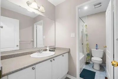 a white bathroom with a sink and a toilet at Cozy Family Home Netflix Backyard and Quiet Area in Mississauga