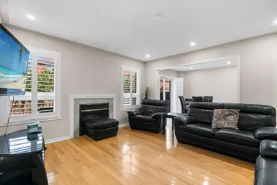a living room with black furniture and a flat screen tv at Cozy Family Home Netflix Backyard and Quiet Area in Mississauga