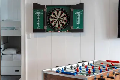 a dart board and darts on a wall at Butterfly Lake House | Cozy & Peaceful Stay in Port Carling