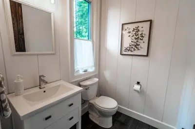 a white bathroom with a toilet and a sink at Butterfly Lake House | Cozy & Peaceful Stay in Port Carling