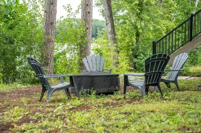 three chairs and a table in the grass at Butterfly Lake House | Cozy & Peaceful Stay in Port Carling