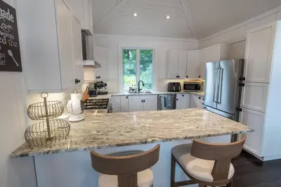a kitchen with a granite counter top and a refrigerator at Butterfly Lake House | Cozy & Peaceful Stay in Port Carling