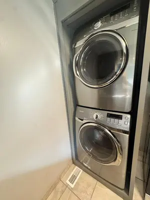 a stainless steel washer and dryer in a room at Luxe Living Prime Location in Kitchener