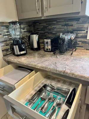 a kitchen with an open drawer with utensils at Luxe Living Prime Location in Kitchener