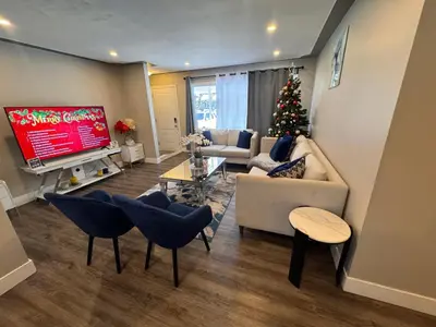 a living room with a christmas tree on the tv at Luxe Living Prime Location in Kitchener