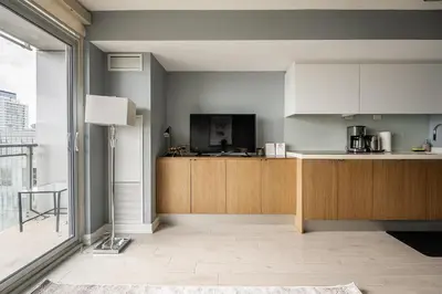a kitchen with wooden cabinets and a large window at Panoramic Lake View 1 Bedroom plus Den Condo Iceboat Terrace Downtown Toronto in Toronto