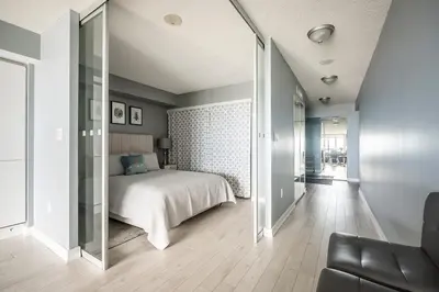 a bedroom with a bed and a large mirror at Panoramic Lake View 1 Bedroom plus Den Condo Iceboat Terrace Downtown Toronto in Toronto