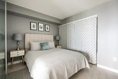 a bedroom with a white bed and a window at Panoramic Lake View 1 Bedroom plus Den Condo Iceboat Terrace Downtown Toronto in Toronto