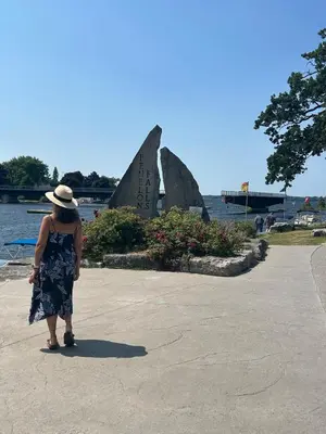 a woman in a hat standing in front of a statue at Water Front Cottage - Balsam Lake in Victoria Road