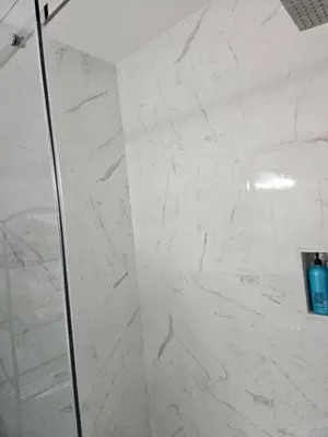 a bathroom with a shower with white marble walls at Beautiful 3 bedrooms, 2 bathrooms, 4 beds sleep 8, basement close to Falls in Niagara Falls