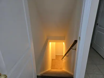a staircase with a light at the end of a door at One Bed basement Room in Brampton
