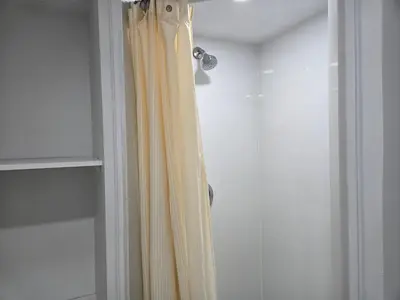 a shower with a yellow shower curtain in a bathroom at One Bed basement Room in Brampton