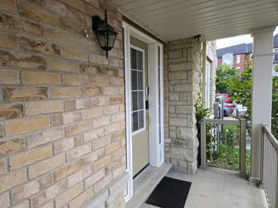 a brick house with a white door and a porch at One Bed basement Room in Brampton