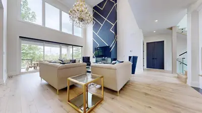 a living room with two couches and a chandelier at Lucky Mansion - a Luxury Villa in Fort Erie ! in Fort Erie