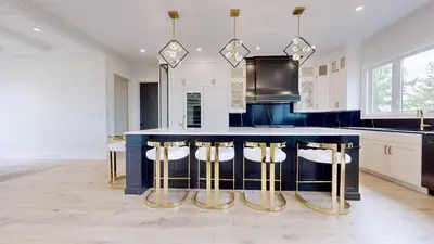 a kitchen with a blue island with bar stools at Lucky Mansion - a Luxury Villa in Fort Erie ! in Fort Erie
