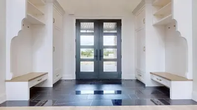 a large white room with a door and two benches at Lucky Mansion - a Luxury Villa in Fort Erie ! in Fort Erie