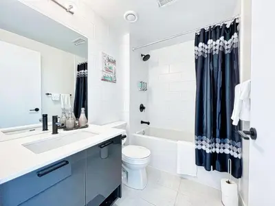 a bathroom with a sink and a toilet and a tub at The Panorama Penthouse - 180 Views and Free Parking by Instant Suites in Toronto