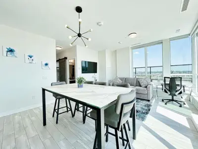 a dining room and living room with a table and chairs at The Panorama Penthouse - 180 Views and Free Parking by Instant Suites in Toronto