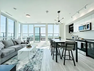 a kitchen and living room with a couch and a table at The Panorama Penthouse - 180 Views and Free Parking by Instant Suites in Toronto
