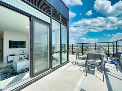 a patio with a table and chairs on a balcony at The Panorama Penthouse - 180 Views and Free Parking by Instant Suites in Toronto
