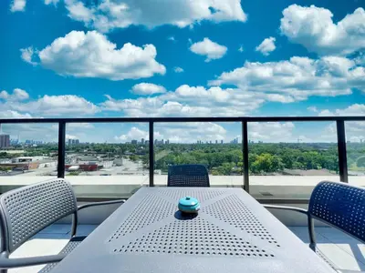 a table on a balcony with a view of the city at The Panorama Penthouse - 180 Views and Free Parking by Instant Suites in Toronto