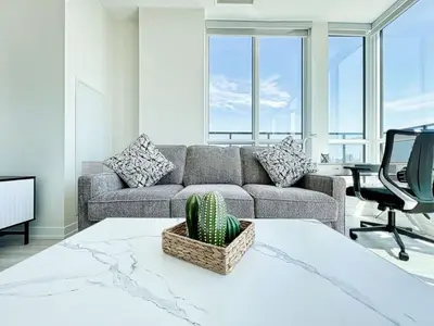 a living room with a couch and a chair at The Panorama Penthouse - 180 Views and Free Parking by Instant Suites in Toronto