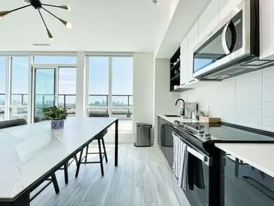 a kitchen with a table and a large window at The Panorama Penthouse - 180 Views and Free Parking by Instant Suites in Toronto