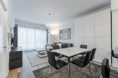 a dining room and living room with a table and chairs at Shore Breeze in Toronto