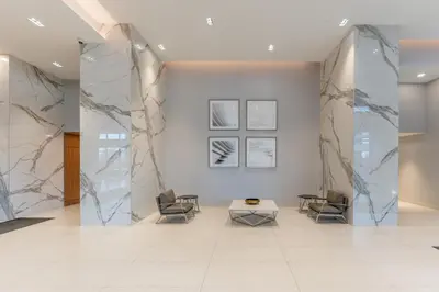 a lobby with marble walls and chairs and a table at Shore Breeze in Toronto