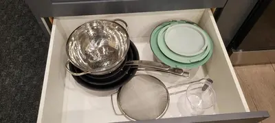 a drawer filled with pots and pans and a plate at Modern Loft with Immersive Theatre Experience in Milton