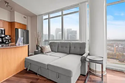 a living room with a couch and some windows at Downtown Condo with Picturesque View in Toronto