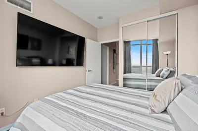 a white bedroom with a large bed and a window at Downtown Condo with Picturesque View in Toronto